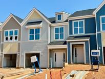 New townhomes featuring attached garages, varied siding colors, and a classic architectural style at 91 Ripple Way # 213, Clayton, NC 27520