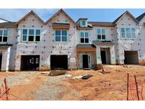 New construction townhomes with garage and covered doorway with unfinished landscaping on a sunny day at 91 Ripple Way # 213, Clayton, NC 27520