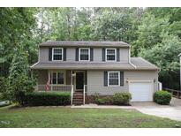 Charming two-story home with a well-manicured lawn and cozy front porch at 116 Trinity Woods Dr, Raleigh, NC 27607