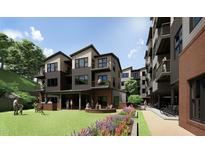Modern apartments featuring a communal outdoor green space with a grill, seating, and manicured landscaping at 140 Two Hills Dr # 302C, Carrboro, NC 27510