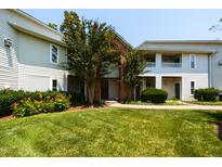 Inviting exterior view of a multi-story building with lush lawn and mature trees on a sunny day at 1911 Falls Landing Dr # 103, Raleigh, NC 27614