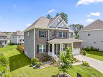 Beautiful two-story home with manicured lawn and attached garage with brick and siding accents at 2527 Sidewinder Ct, Apex, NC 27523