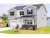 Charming two-story home with gray siding, black shutters, a two-car garage, and well-maintained landscaping at 361 Providence Creek Dr, Fuquay Varina, NC 27526