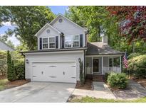 Charming two-story home featuring a front porch, attached garage and well-maintained landscaping at 425 Hidden Cellars Dr, Holly Springs, NC 27540