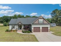 Charming two-story home featuring a two-car garage, manicured lawn, and inviting front porch at 7055 Nc-242, Dunn, NC 28334