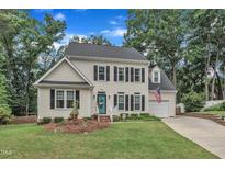 Charming two-story home with manicured lawn, brick-lined driveway, and inviting curb appeal at 7613 Percy Ct, Raleigh, NC 27613