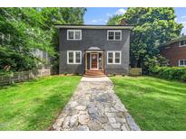 Charming two-story home with a stone walkway leading to the front door and well-manicured lawn at 924 W Trinity Ave, Durham, NC 27701