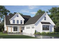 Stunning two-story modern farmhouse featuring white siding, black trim, a three-car garage and a well-manicured lawn at 1053 Azalea Garden Cir, Raleigh, NC 27603