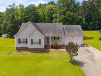 Charming single-story home with a manicured lawn and attached garage, perfect for suburban living at 106 Oak Rd, Butner, NC 27509
