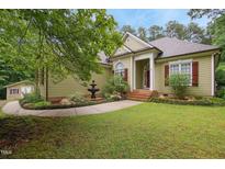 Charming home featuring a fountain and a lush landscaped yard with a well-maintained lawn at 109 Springwood Dr, Wake Forest, NC 27587
