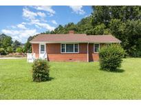 Charming brick home with well-maintained lawn and mature trees offering classic curb appeal at 1209 Bobbitt Dr, Garner, NC 27529