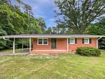 Charming one-story brick home with a covered carport and a well-maintained front yard at 1311 Meadow Ln, Chapel Hill, NC 27516
