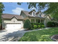 Charming home with a two-car garage, well-manicured lawn, and lush landscaping at 150 Churchill Rd, Louisburg, NC 27549