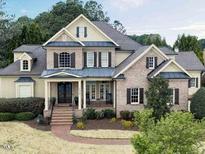 Charming brick home with a covered front porch and beautifully landscaped front yard at 1512 Obrien Cir, Wake Forest, NC 27587