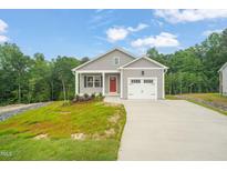 Charming single-story home with a well-manicured lawn, attached garage and inviting red front door at 156 Harmony Trl, Broadway, NC 27505
