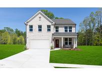 Beautiful white brick two-story home featuring a manicured lawn and an attached two-car garage at 226 Macon Lake Drive # 41, Apex, NC 27523