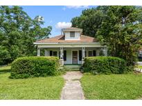 Charming home featuring a covered front porch with manicured landscaping and mature trees at 2631 Harvard Ave, Durham, NC 27703