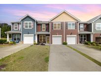 Charming townhomes featuring colorful siding, individual driveways, and attached garages at 3403 Cardinal Lake Dr, Durham, NC 27704