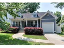 Charming, blue-gray two-story home with a well-manicured front yard and attached one-car garage at 604 Mills St, Raleigh, NC 27608