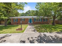 Charming brick home with blue shutters, lush green lawn, and mature trees creating a welcoming curb appeal at 722 Baker St, Oxford, NC 27565