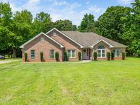 Charming brick home with a well-manicured lawn and symmetrical landscaping that enhances its curb appeal at 8917 Thompson Mill Rd, Wake Forest, NC 27587