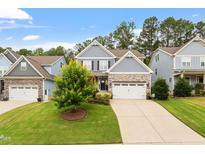 Charming two-story home featuring a well-manicured lawn, stone accents, and a two-car garage at 958 Bay Bouquet Ln, Apex, NC 27523
