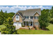 Beautiful two-story brick home with a two-car garage and manicured lawn at 109 Lake Point Dr, Clayton, NC 27527