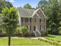 Charming two-story brick home with a well-manicured lawn and mature trees, perfect for Gathering living at 111 Canberra Ct, Cary, NC 27513