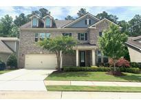 Charming two-story brick home featuring a two-car garage, well-manicured lawn, and inviting front porch at 1205 Capstone Dr, Durham, NC 27713