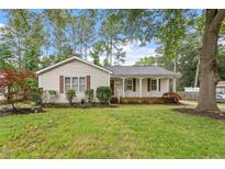 Charming single-story home featuring a well-maintained lawn, trees, and classic siding at 1317 Swallow Dr, Raleigh, NC 27606