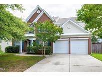 Traditional brick home featuring an attached two-car garage and well-manicured landscaping at 201 Masterwood Way, Morrisville, NC 27560