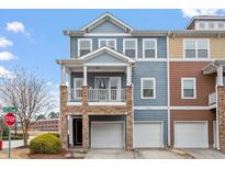Charming two-story townhome featuring stone accents, a balcony, and individual garages at 2060 Jersey City Pl, Apex, NC 27523
