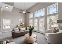 Bright living room features a ceiling fan, large windows, and neutral décor at 2060 Jersey City Pl, Apex, NC 27523