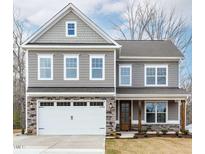 Charming two-story home featuring a gray facade, stone accents, and a welcoming front porch at 2101 Wimberly Woods Dr, Sanford, NC 27330