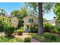 Charming two-story home with a brick walkway, lush landscaping, and a welcoming green front door at 225 Vance St, Chapel Hill, NC 27516