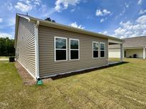 Exterior shot showcasing the house's vinyl siding and well-maintained lawn at 23 Rolling Banks Dr, Louisburg, NC 27549