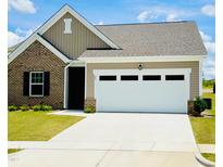 Charming single-Gathering home boasting a two-car garage and well-maintained landscaping at 23 Rolling Banks Dr, Louisburg, NC 27549
