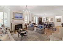 Bright, airy living room with fireplace and view into dining room; features hardwood floors and elegant chandelier at 2813 Market Bridge Ln # 104, Raleigh, NC 27608