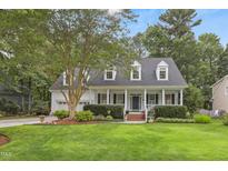 Charming two-story home featuring a covered front porch, beautiful landscaping, and a well-manicured lawn at 314 Chanticlair Dr, Apex, NC 27502