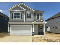 Charming new construction home with gray siding, stone accents, and a two-car garage at 40 Commons Cir, Clayton, NC 27520