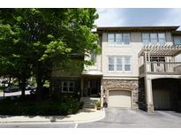 Inviting townhome exterior with stone accents, garage, and mature landscaping at 4810 Glenmist Ct, Raleigh, NC 27612