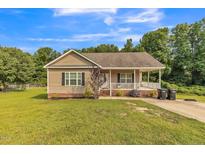 Charming single-story home with a welcoming front porch and well-maintained lawn and landscaping at 54 Lockwood Dr, Clayton, NC 27527
