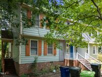 Inviting two-story home featuring a lush green yard and quaint orange window shutters at 5520 Kaplan Dr, Raleigh, NC 27606