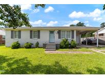 Charming single-story brick home with a well-maintained lawn and covered parking at 729 Carolina Dr, Dunn, NC 28334