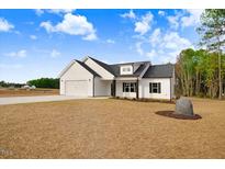 Charming single-story home with white siding, black accents, and an attached two-car garage at 80 Birchtop Cir, Zebulon, NC 27597