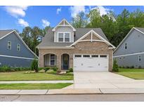 Charming brick home with a well-maintained lawn and a two-car garage, a perfect blend of style and functionality at 857 Whistable Ave, Wake Forest, NC 27587