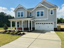 Charming exterior showcasing a well-manicured lawn and a two-car garage at 90 Merle Way, Wendell, NC 27591