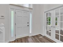 Bright foyer featuring a white front door with sidelights and elegant french doors leading to another room at 100 Windvale Ct, Cary, NC 27518