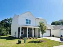 Charming two-story home featuring a brick and white siding exterior, a well-manicured lawn and attached garage at 140 N Keatts Winner Ct, Wilson's Mills, NC 27520