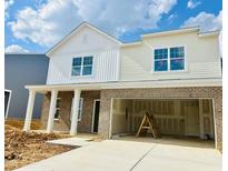 Two-story home featuring brick and vinyl siding, white trim, and an attached two car garage at 140 N Keatts Winner Ct, Wilson's Mills, NC 27520